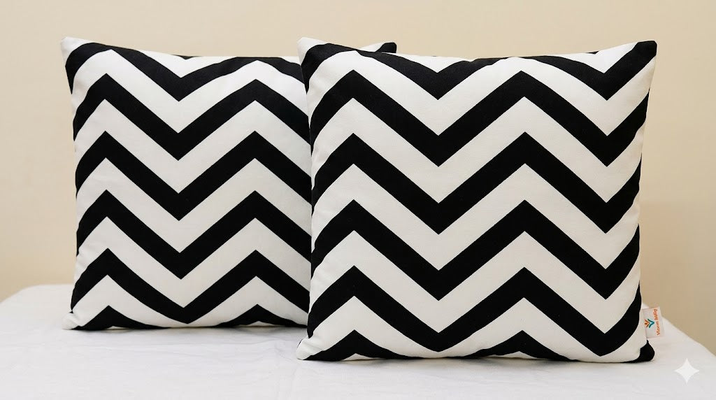 Two black and white chevron patterned pillows on a light-colored surface.