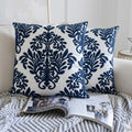 Navy blue and white patterned pillows on a sofa with an open magazine.