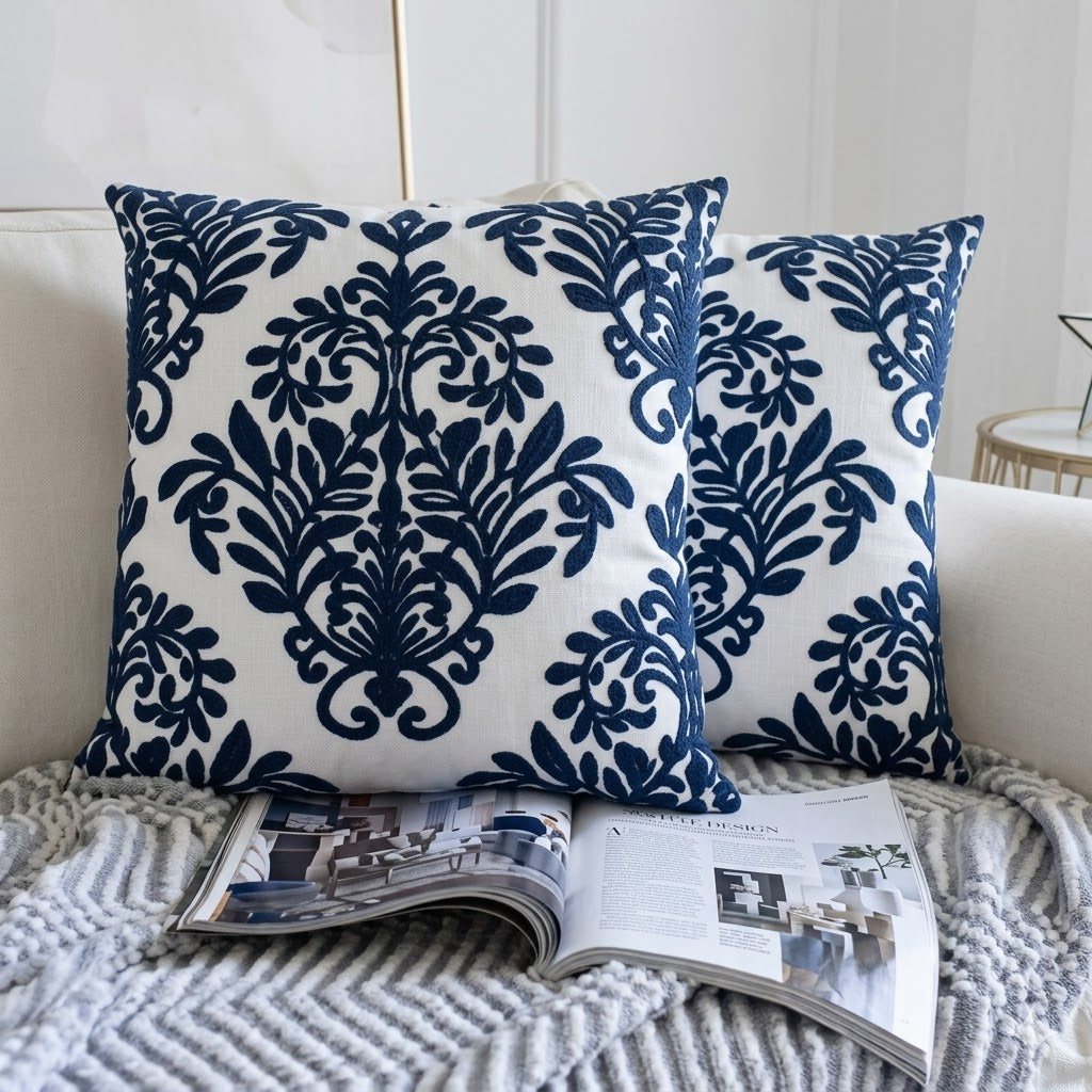 Navy blue and white patterned pillows on a sofa with an open magazine.
