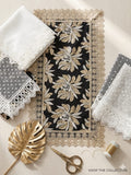 Decorative table mats with lace edges and a gold leaf on a light surface.