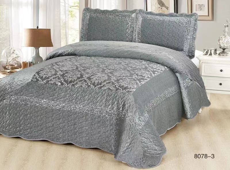 A grey colored quilt with shimmer design