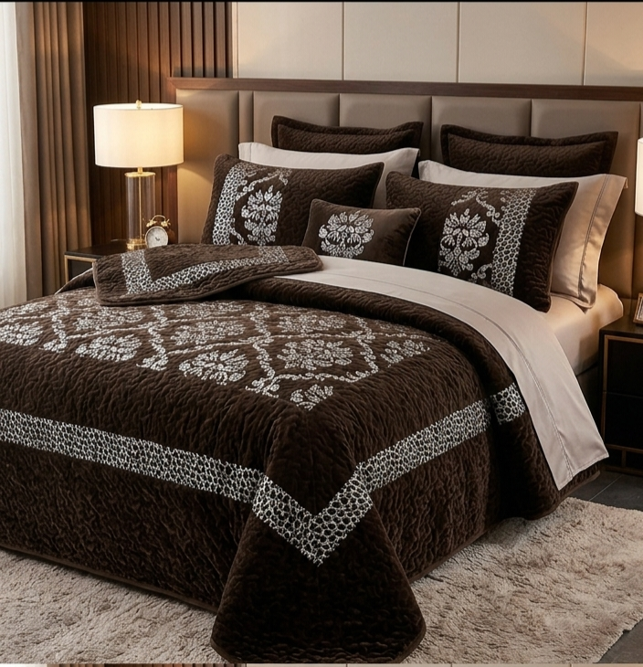 Brown and white patterned bedding set on a bed in a bedroom.