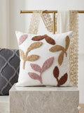 Decorative pillow with leaf pattern on a marble surface