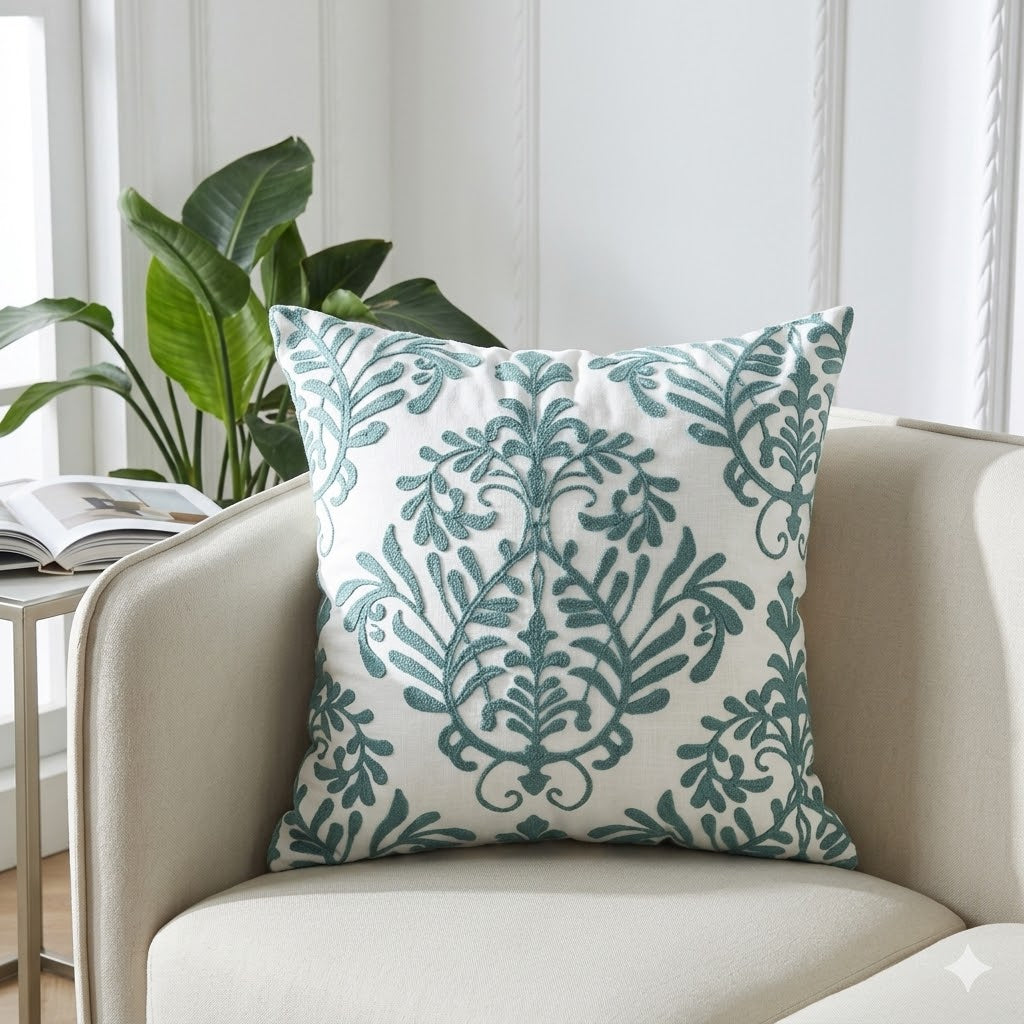 Decorative pillow with green leaf pattern on a beige sofa in a bright room.